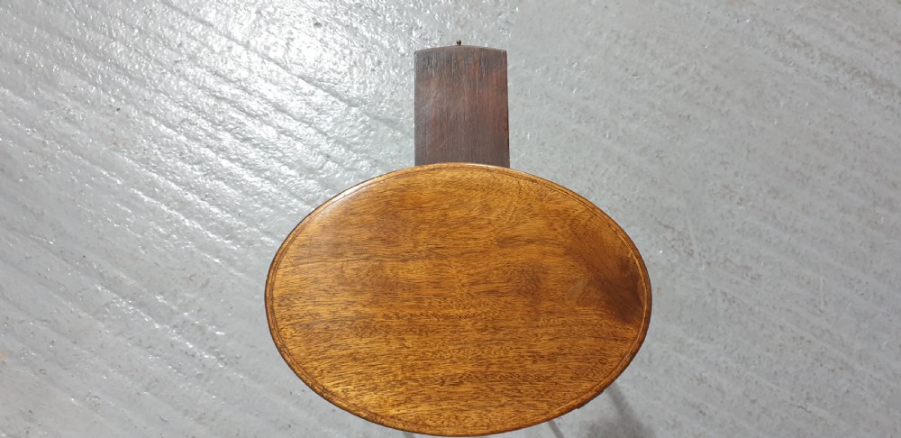 A tall circular mahogany side table featuring a blind fretwork apron and four slender tapered legs. View III