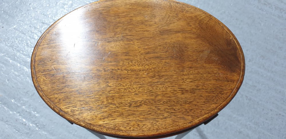 A tall circular mahogany side table featuring a blind fretwork apron and four slender tapered legs. View IV