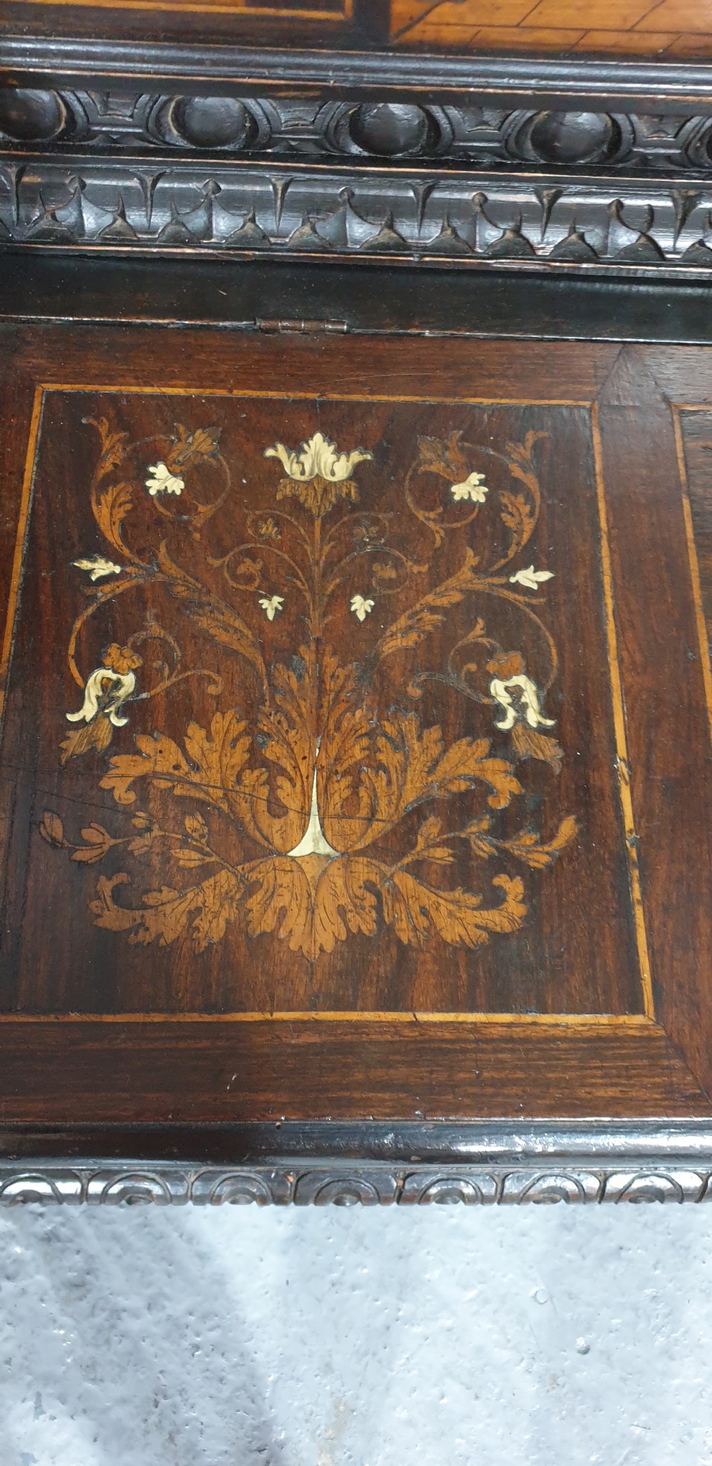 A heavily carved dark walnut Italian hall bench featuring a high backrest with intricate pictorial wood marquetry, winged griffin cresting, and lion paw feet. View XII