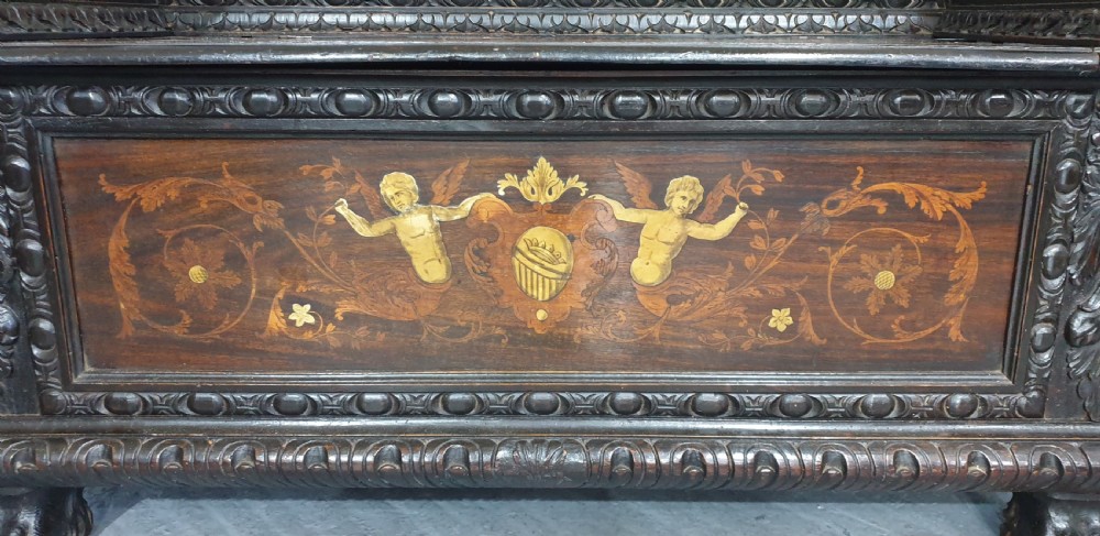 A heavily carved dark walnut Italian hall bench featuring a high backrest with intricate pictorial wood marquetry, winged griffin cresting, and lion paw feet. View XV
