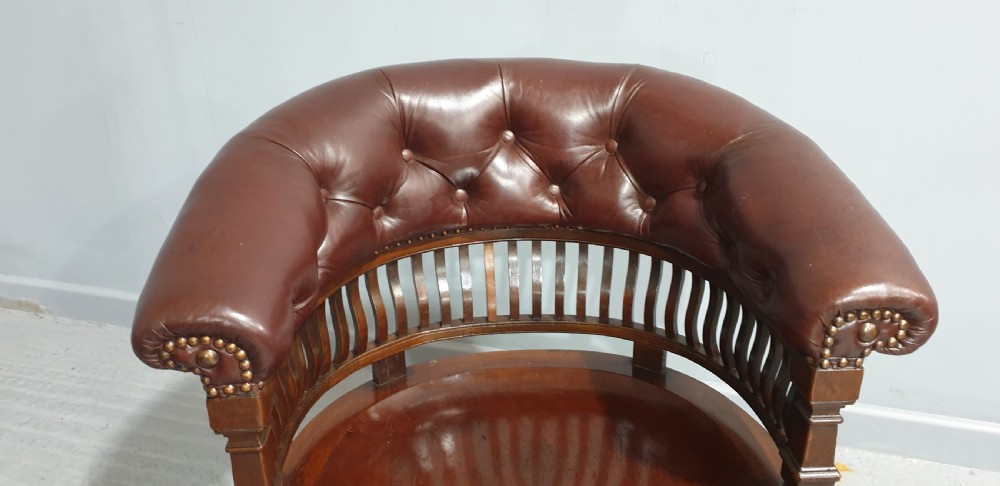 Victorian mahogany desk chair with a deep buttoned brown leather horseshoe backrest, slatted gallery, shaped solid timber seat, and X-frame cross stretchers. View II