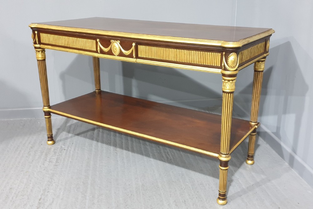 A dark mahogany rectangular console table featuring giltwood fluted legs, a lower shelf, and gold carved swags along the front apron. View II