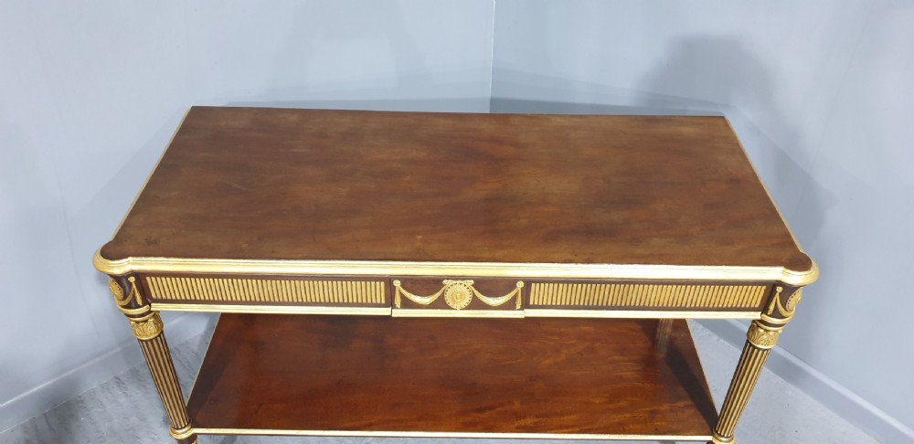 A dark mahogany rectangular console table featuring giltwood fluted legs, a lower shelf, and gold carved swags along the front apron. View IX