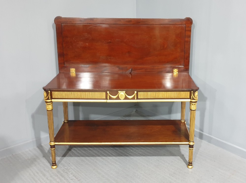 A dark mahogany rectangular console table featuring giltwood fluted legs, a lower shelf, and gold carved swags along the front apron. View XII