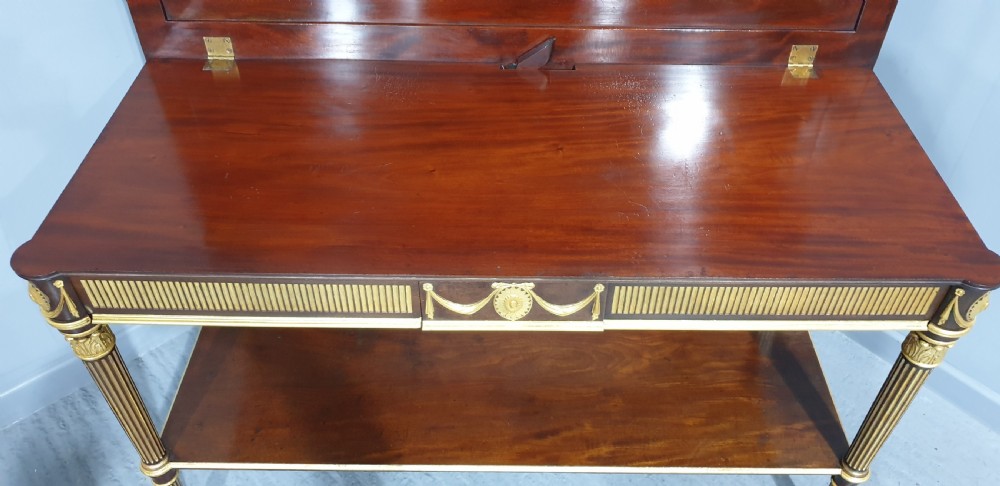 A dark mahogany rectangular console table featuring giltwood fluted legs, a lower shelf, and gold carved swags along the front apron. View XIV