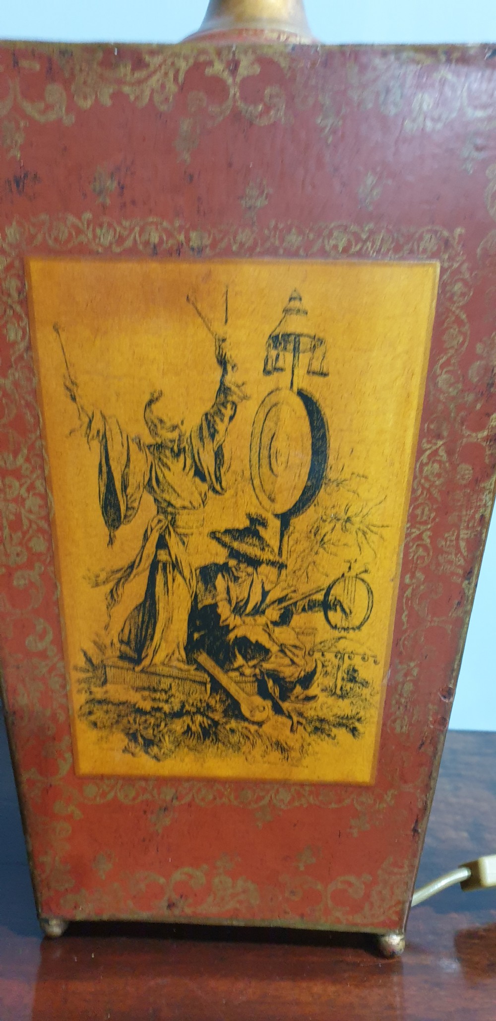 A pair of tapered rectangular red and gold lacquered toleware table lamps decorated with hand-painted chinoiserie figures and brass fittings. View VI