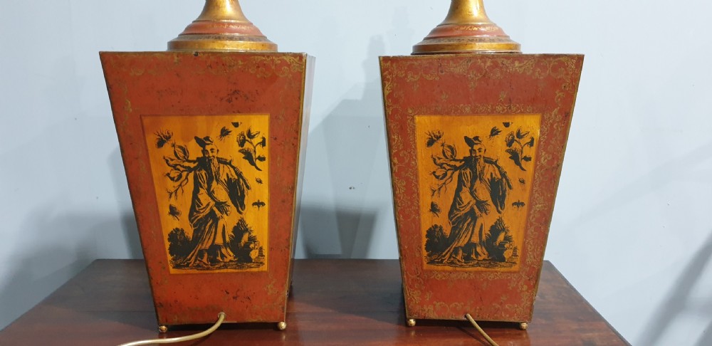A pair of tapered rectangular red and gold lacquered toleware table lamps decorated with hand-painted chinoiserie figures and brass fittings. View VII