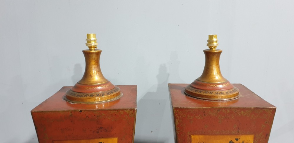A pair of tapered rectangular red and gold lacquered toleware table lamps decorated with hand-painted chinoiserie figures and brass fittings. View VIII
