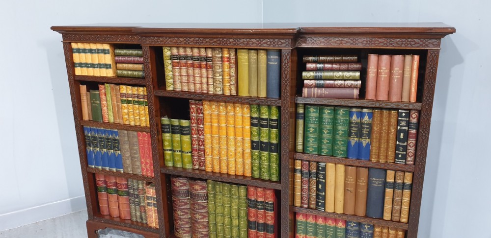 A low, wide mahogany breakfront open bookcase featuring three sections of adjustable shelves with carved fretwork detail along the top edge. View III