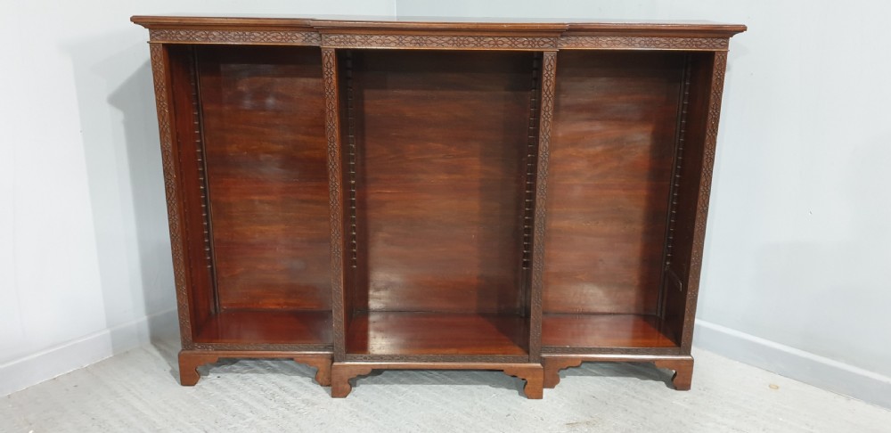 A low, wide mahogany breakfront open bookcase featuring three sections of adjustable shelves with carved fretwork detail along the top edge. View XIII