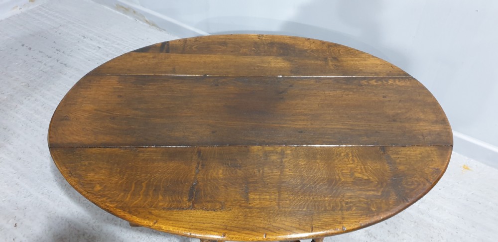 A low solid oak oval coffee table featuring turned gateleg supports and a warm brown timber patina. View III