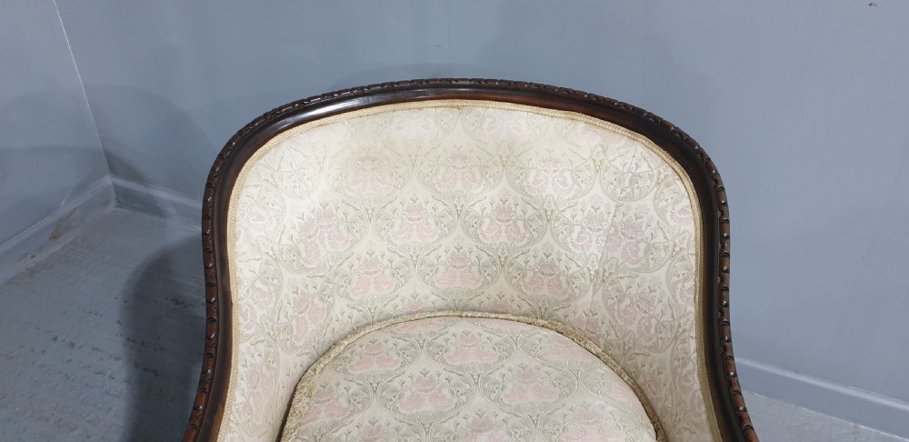 A pair of Victorian mahogany hoop-backed easy chairs upholstered in cream patterned damask fabric with carved legs on brass castors. View VII