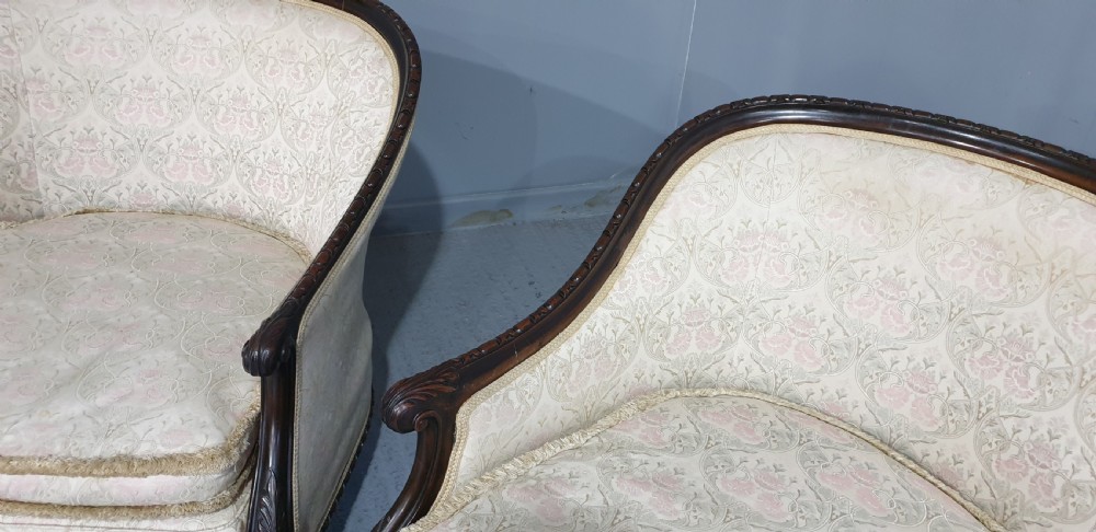 A pair of Victorian mahogany hoop-backed easy chairs upholstered in cream patterned damask fabric with carved legs on brass castors. View IX