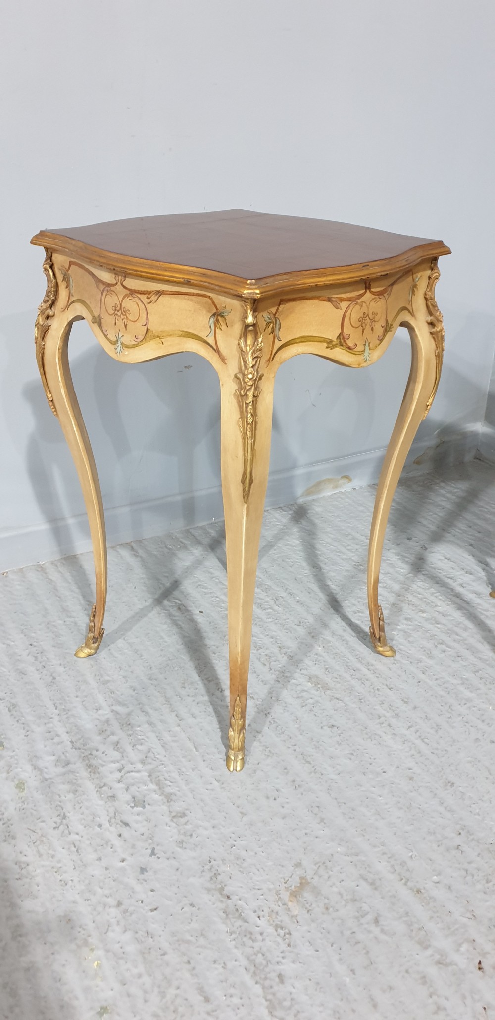 A pair of French Louis XV style tall side tables featuring cream painted cabriole legs with gilt carved embellishments and wooden tops. View III
