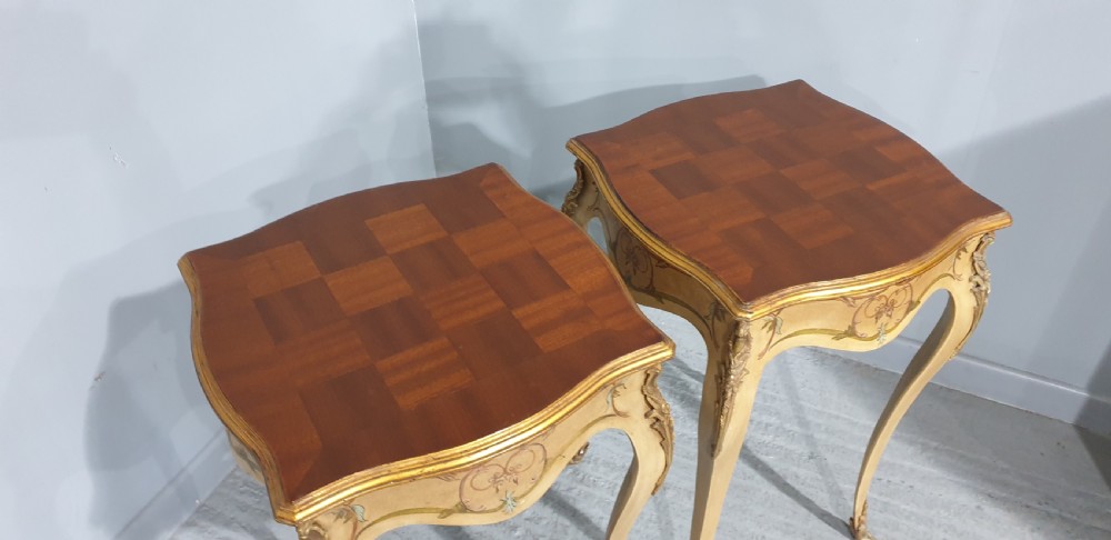 A pair of French Louis XV style tall side tables featuring cream painted cabriole legs with gilt carved embellishments and wooden tops. View VI