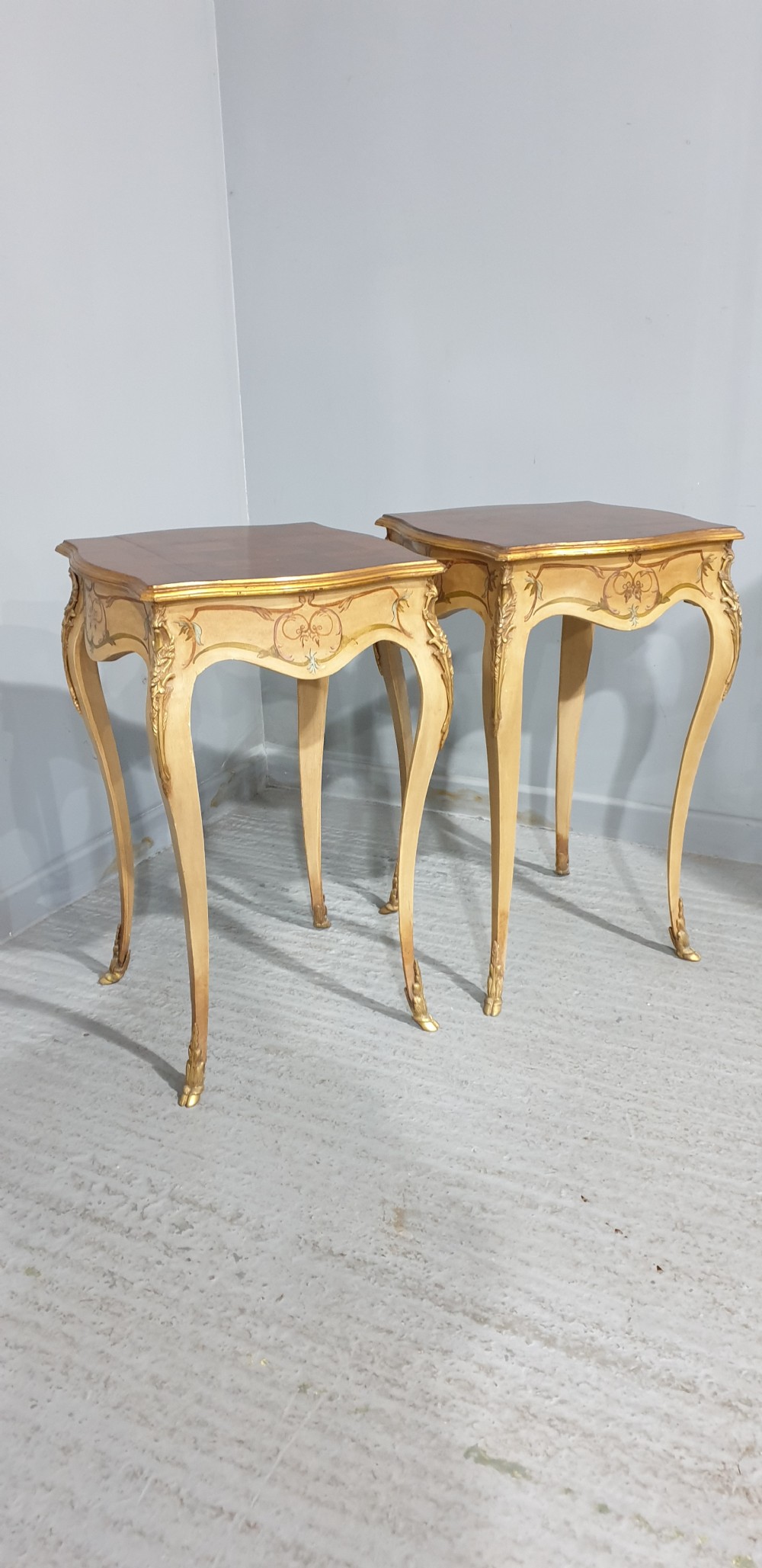 A pair of French Louis XV style tall side tables featuring cream painted cabriole legs with gilt carved embellishments and wooden tops. View VII