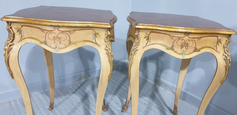 A pair of French Louis XV style tall side tables featuring cream painted cabriole legs with gilt carved embellishments and wooden tops. View VIII