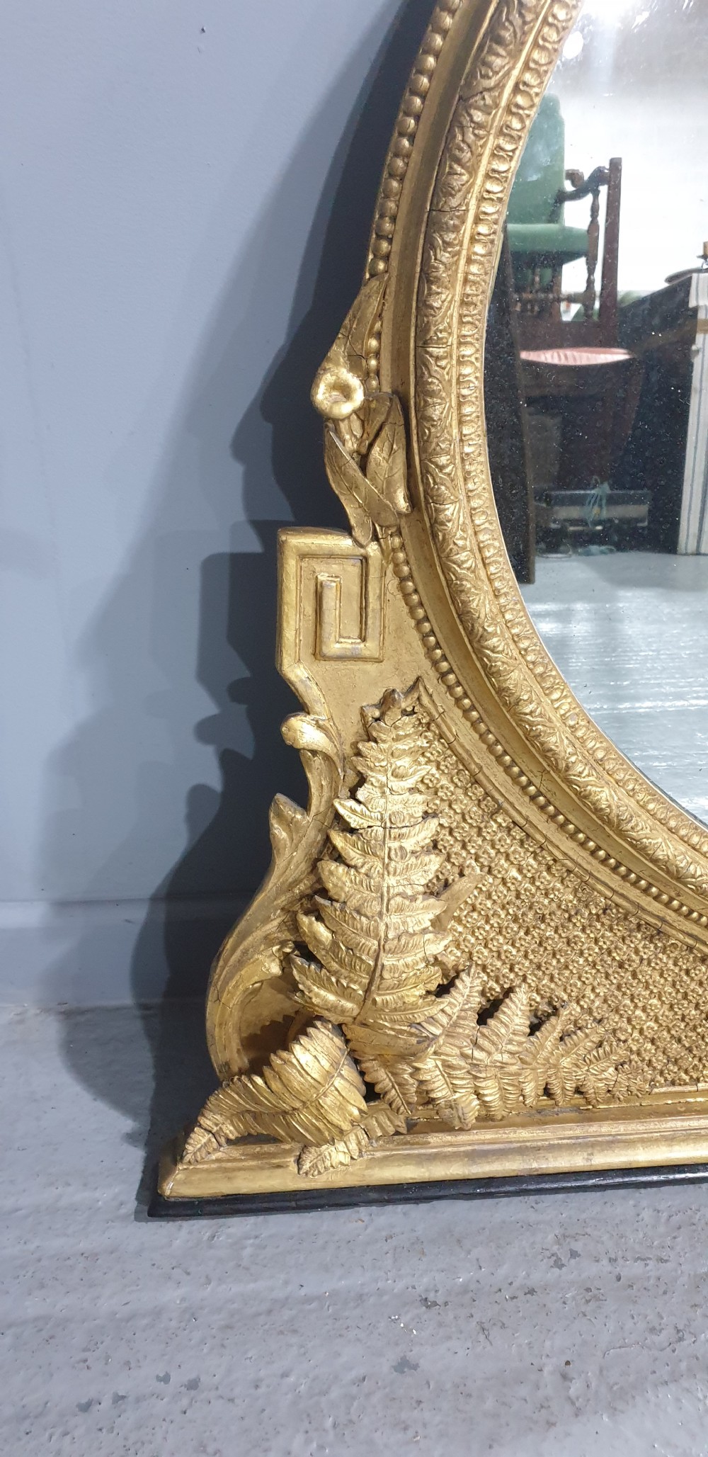 A large High Victorian arched overmantel mirror featuring a gold gilded frame decorated with carved fern leaf motifs, floral cresting, and geometric spandrel detailing. View III