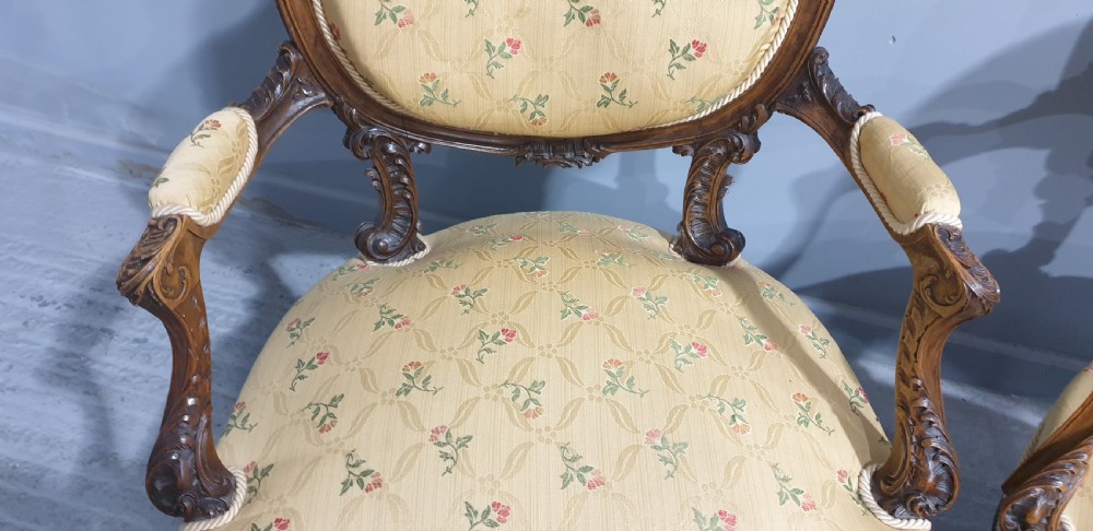A pair of French carved mahogany open armchairs upholstered in patterned yellow floral fabric with cabriole legs. View III