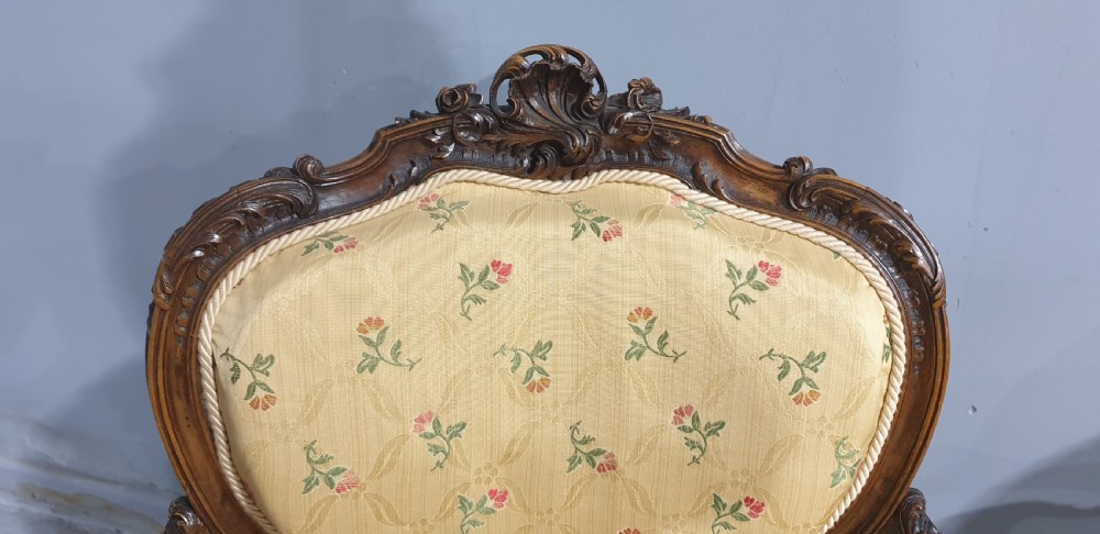 A pair of French carved mahogany open armchairs upholstered in patterned yellow floral fabric with cabriole legs. View IV