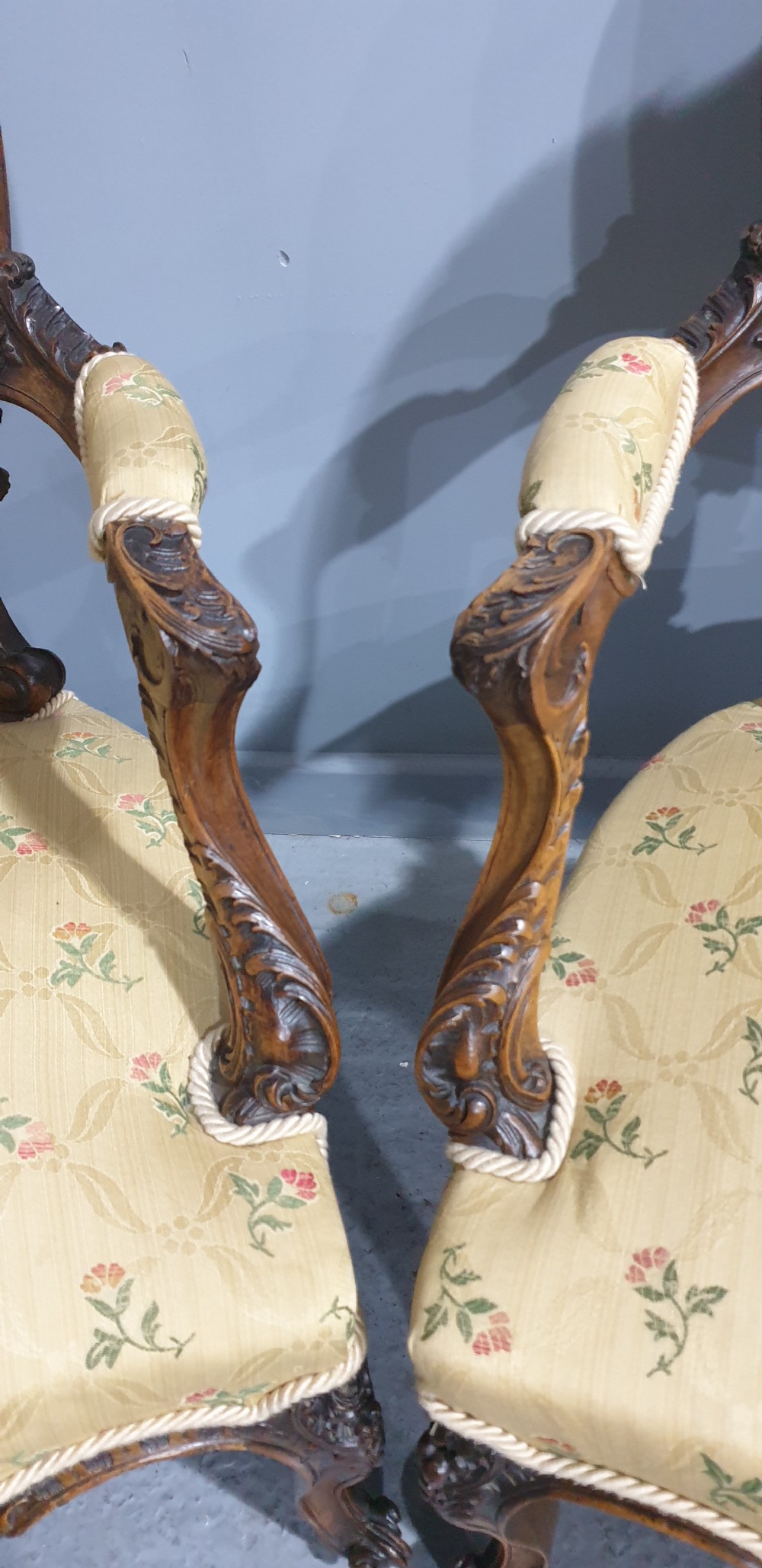 A pair of French carved mahogany open armchairs upholstered in patterned yellow floral fabric with cabriole legs. View V