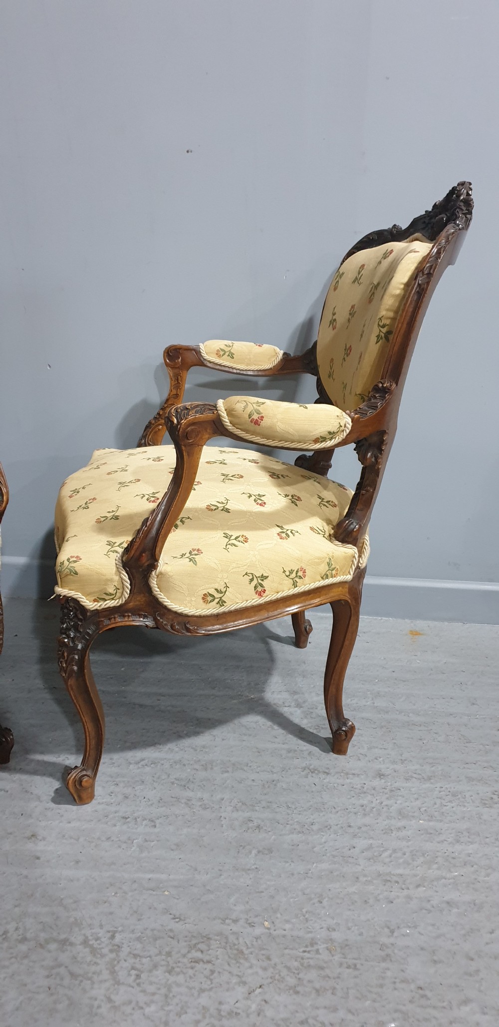 A pair of French carved mahogany open armchairs upholstered in patterned yellow floral fabric with cabriole legs. View VII