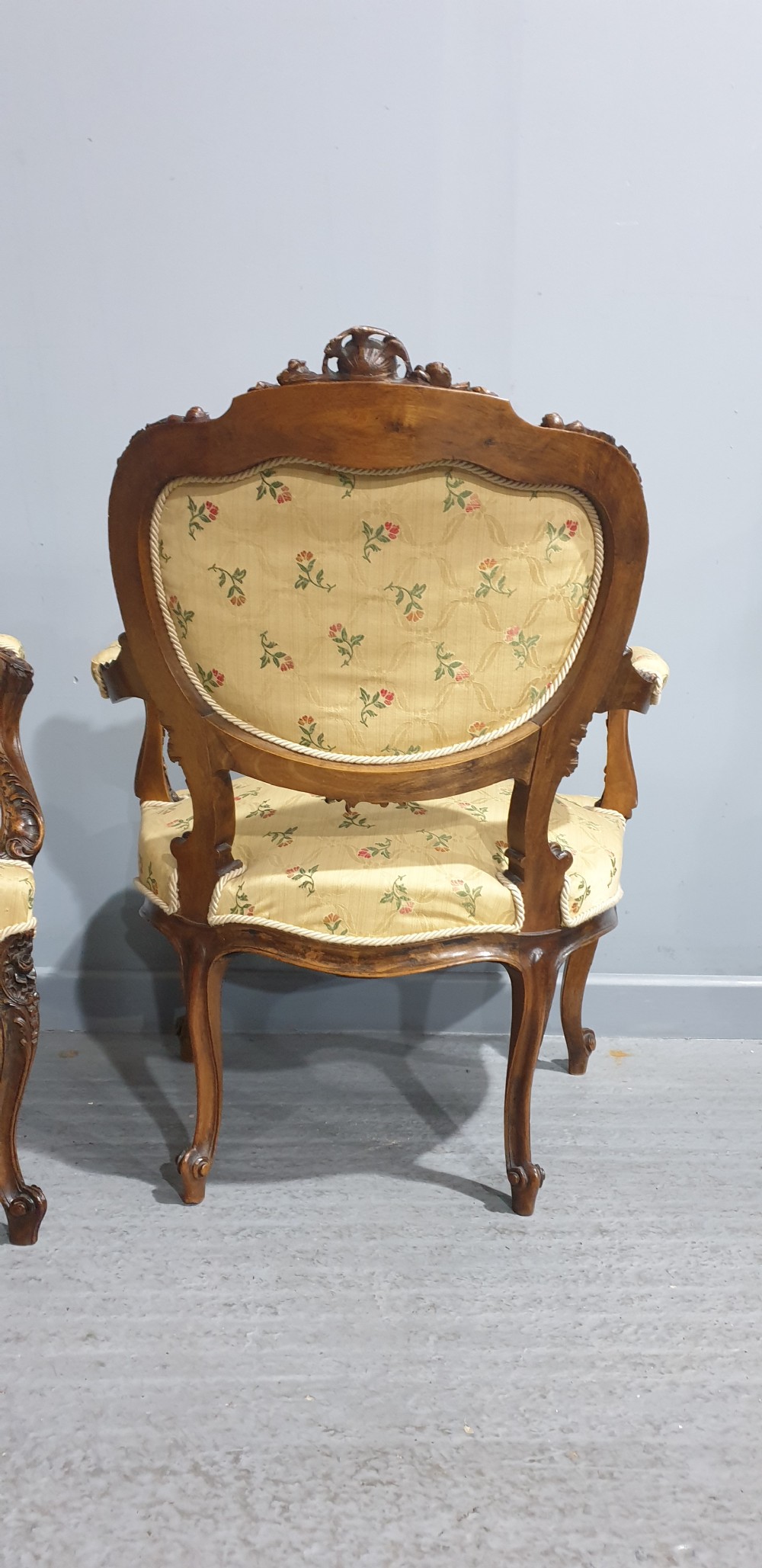 A pair of French carved mahogany open armchairs upholstered in patterned yellow floral fabric with cabriole legs. View VIII