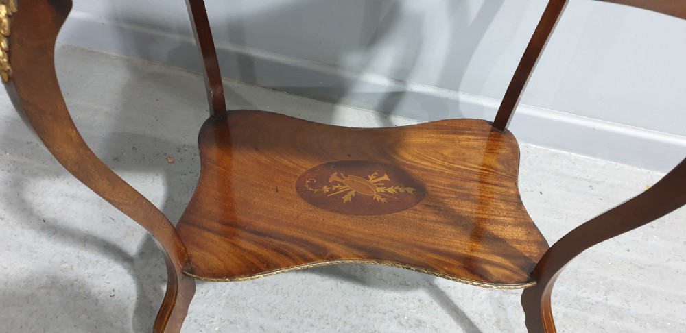 A French-style two-tier occasional table featuring marquetry wood inlays, cabriole legs, brass corner mounts, and a pierced brass gallery rim around the top surface. View VIII