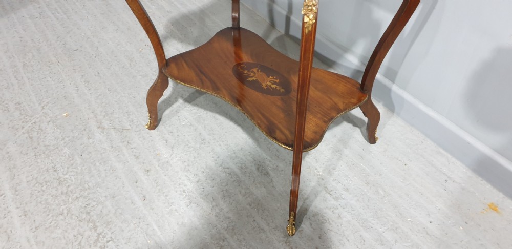 A French-style two-tier occasional table featuring marquetry wood inlays, cabriole legs, brass corner mounts, and a pierced brass gallery rim around the top surface. View IX
