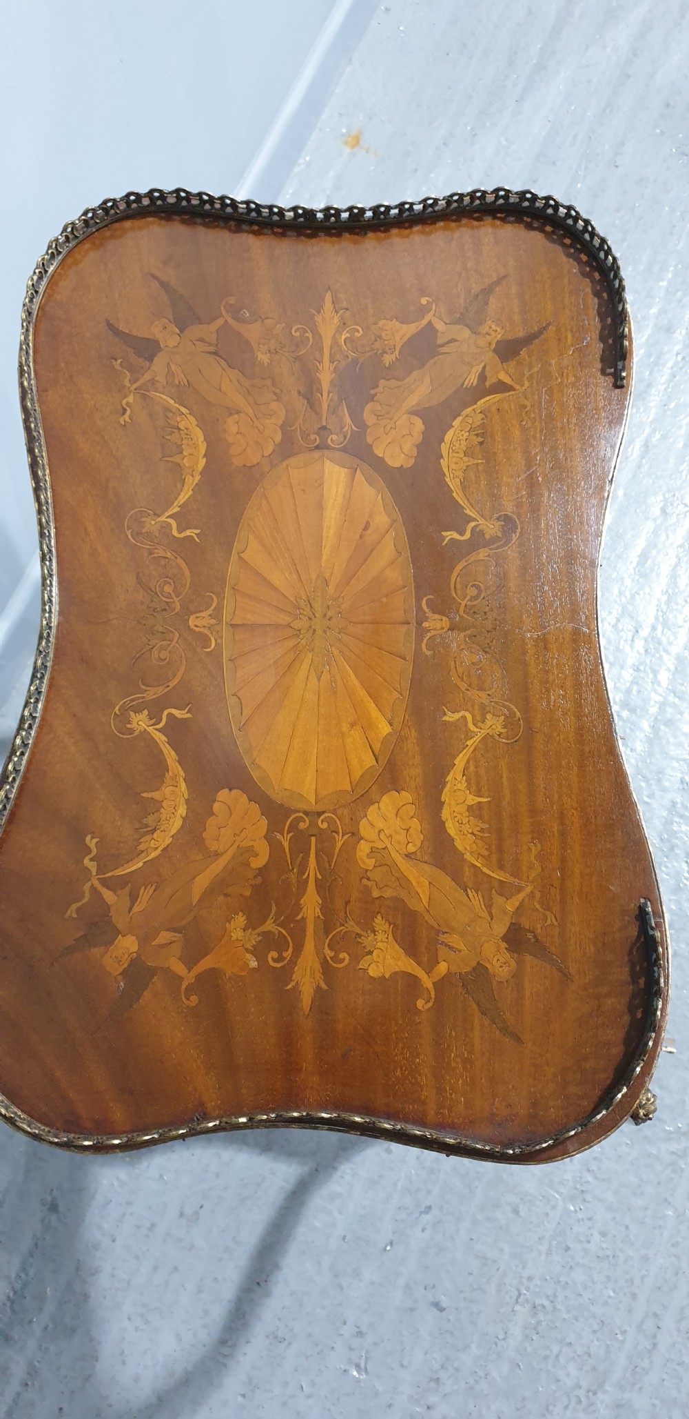 A French-style two-tier occasional table featuring marquetry wood inlays, cabriole legs, brass corner mounts, and a pierced brass gallery rim around the top surface. View XII
