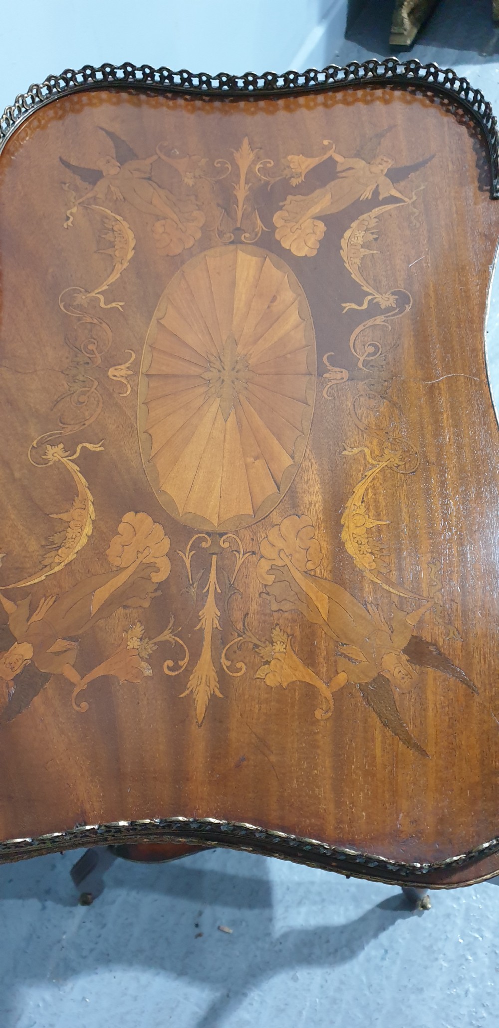 A French-style two-tier occasional table featuring marquetry wood inlays, cabriole legs, brass corner mounts, and a pierced brass gallery rim around the top surface. View XIII
