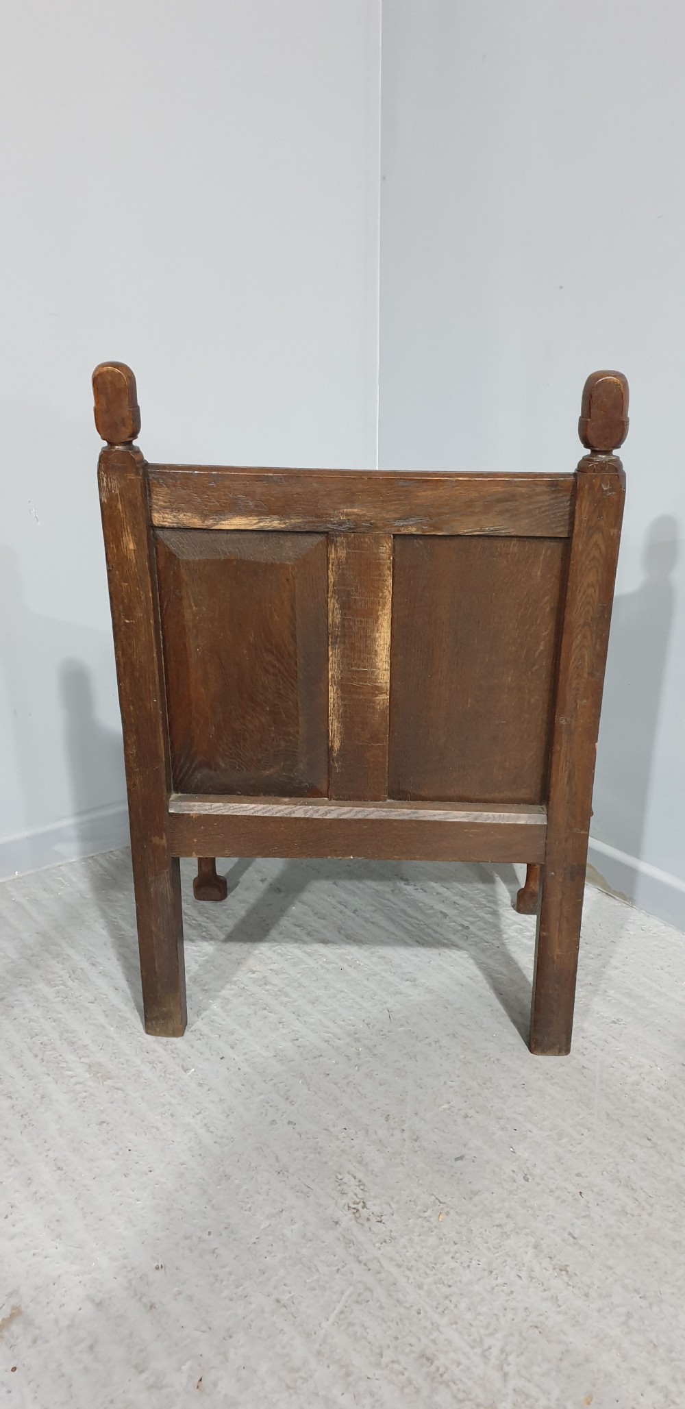 A small carved oak settle featuring a floral relief panelled back, turned finials, shaped armrests, and cabriole front legs. View VII