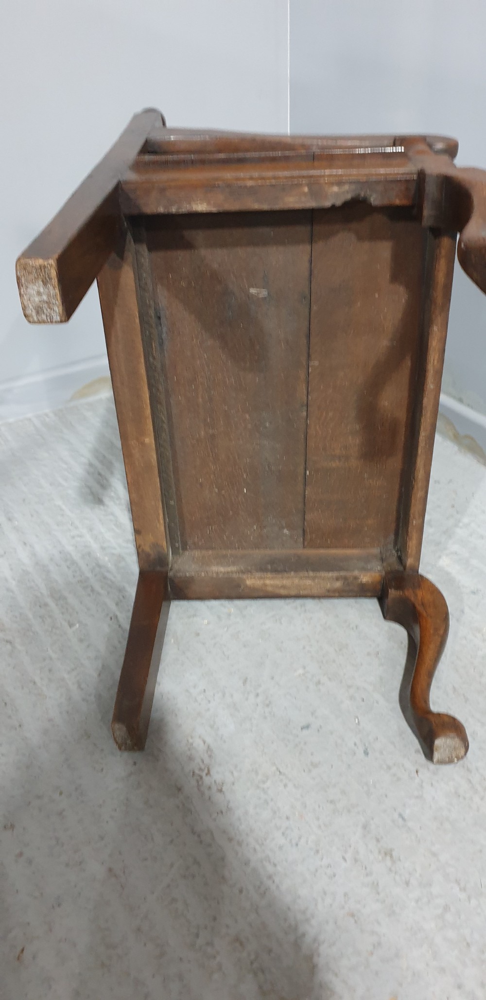 A small carved oak settle featuring a floral relief panelled back, turned finials, shaped armrests, and cabriole front legs. View VIII