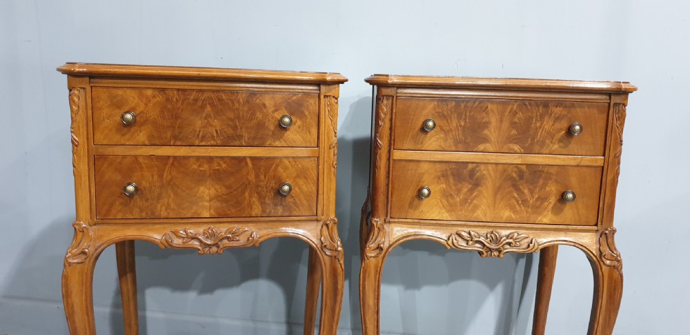 A pair of warm brown walnut bedside chests featuring two drawers with brass knobs, carved aprons, and long cabriole legs. View III