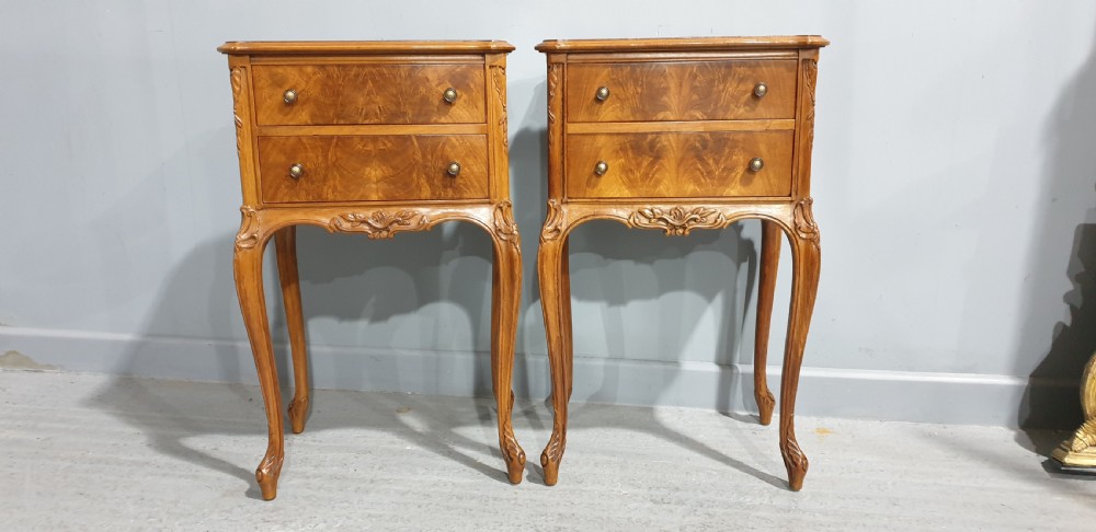 A pair of warm brown walnut bedside chests featuring two drawers with brass knobs, carved aprons, and long cabriole legs. View V