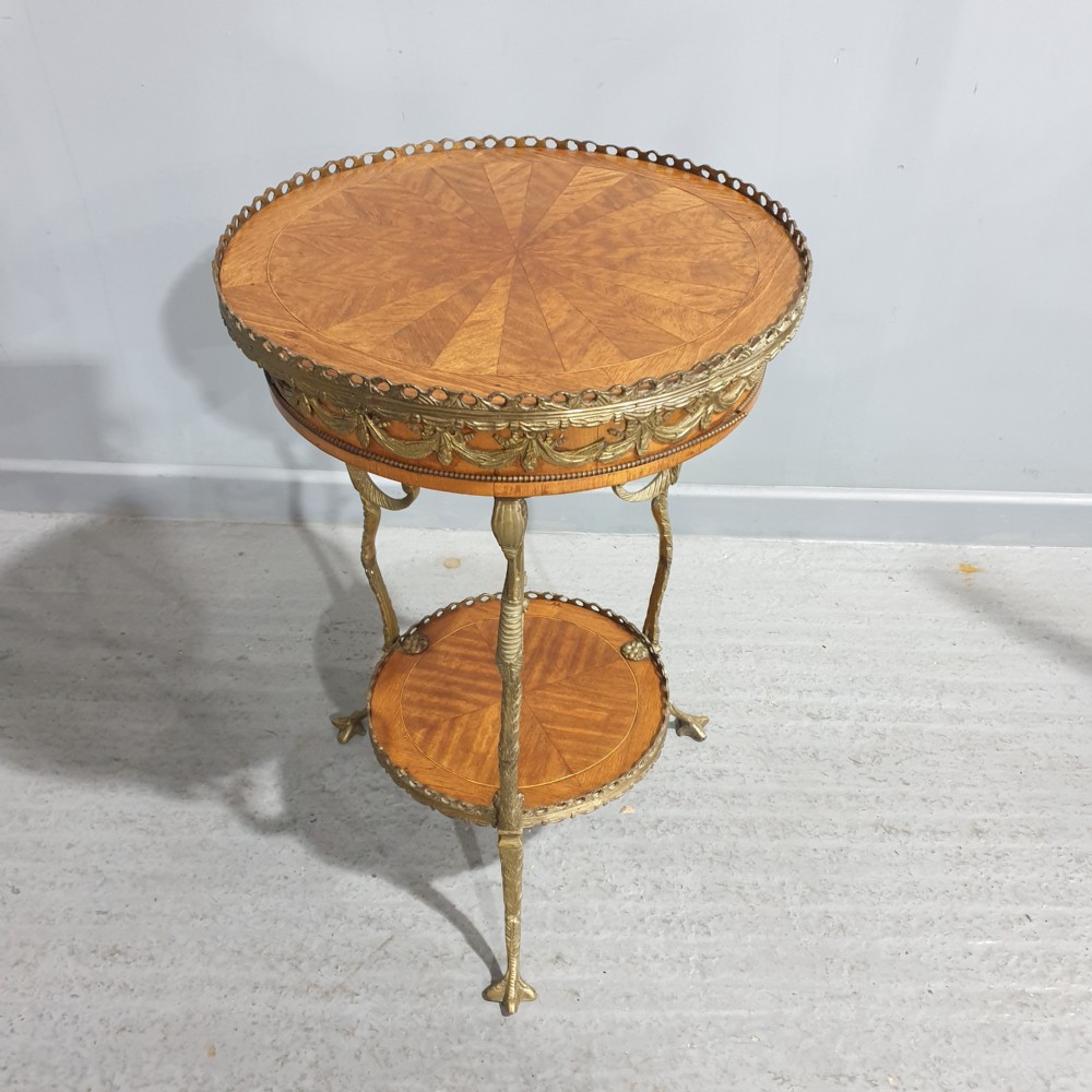 A round French side table featuring two tiers of sunburst parquetry veneer, decorative brass mounts, and a pierced gallery rim.