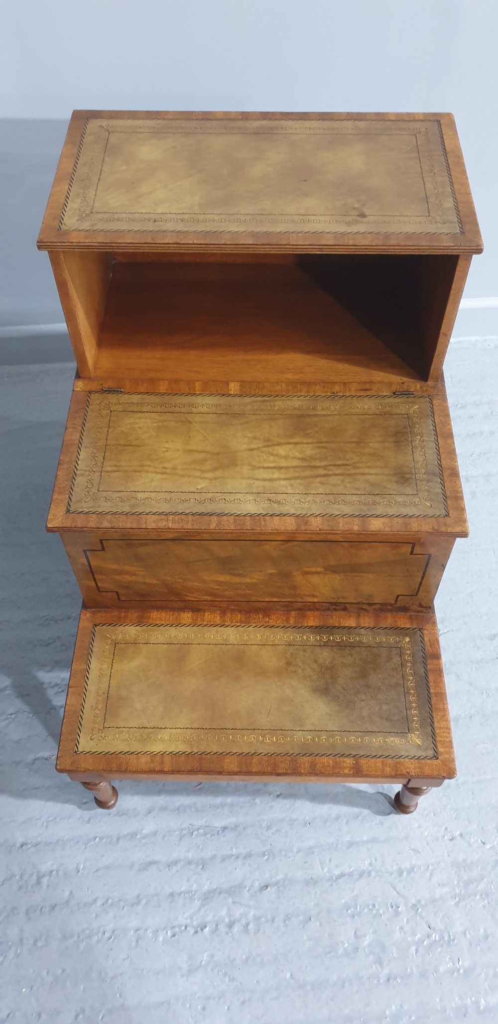 A set of three-tier Victorian mahogany library steps with leather-inset treads, turned legs, and side brass fittings. View III