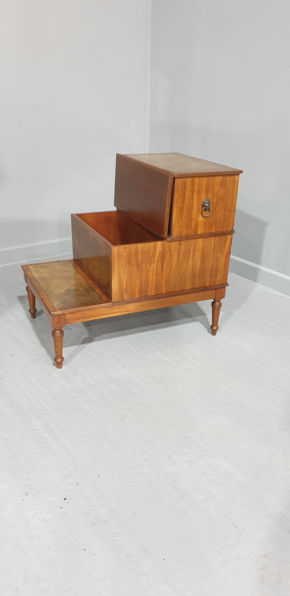 A set of three-tier Victorian mahogany library steps with leather-inset treads, turned legs, and side brass fittings. View V