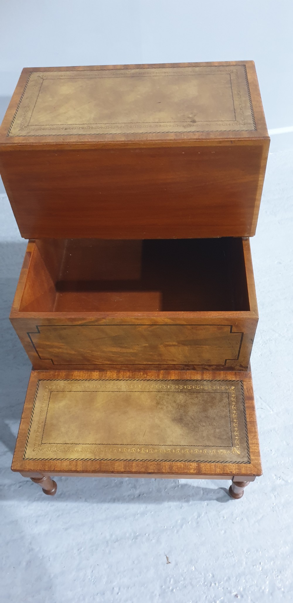 A set of three-tier Victorian mahogany library steps with leather-inset treads, turned legs, and side brass fittings. View VII