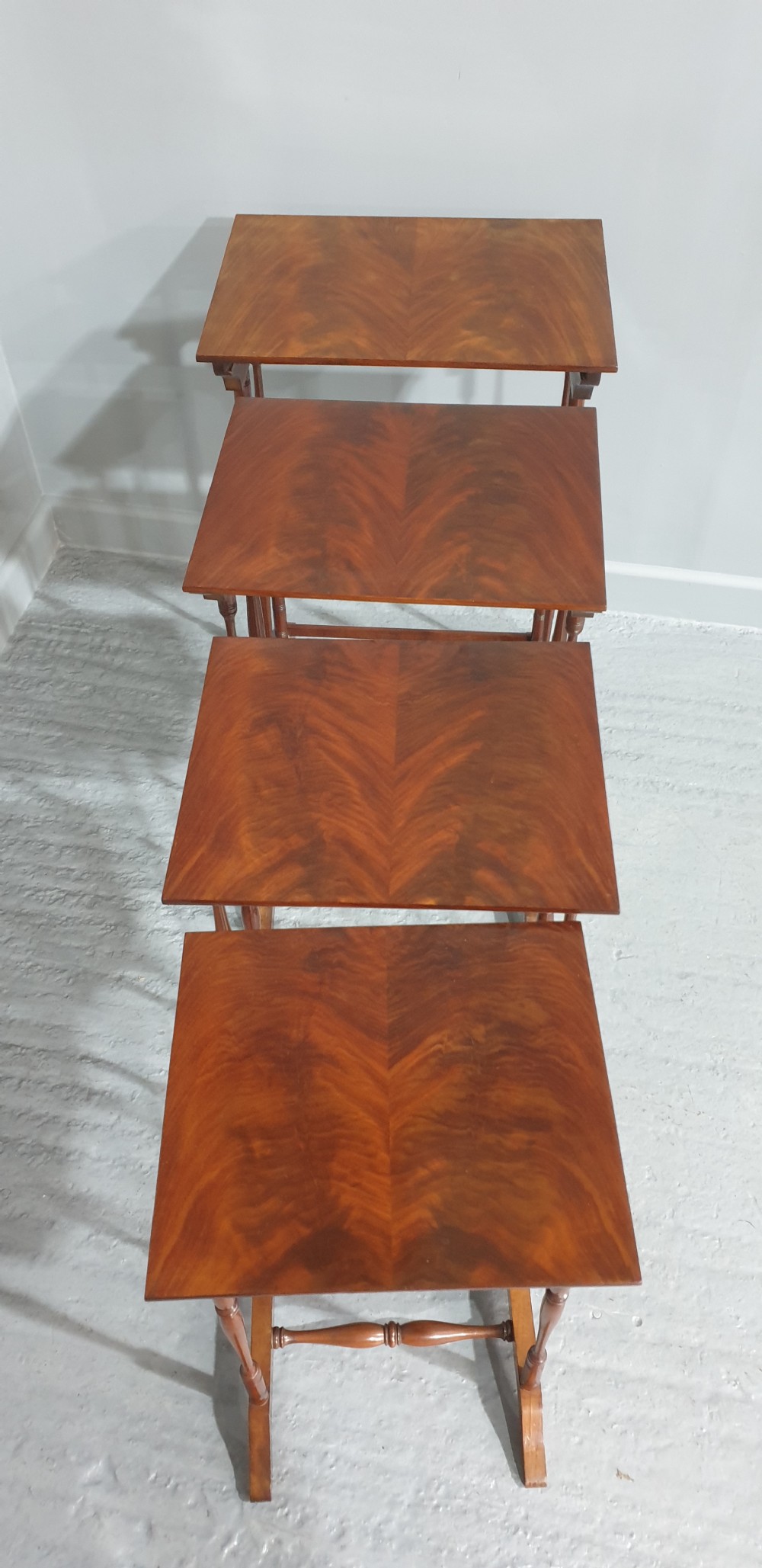 A set of four Edwardian mahogany nesting tables with rectangular tops, slender turned legs, and stretcher bases. View III