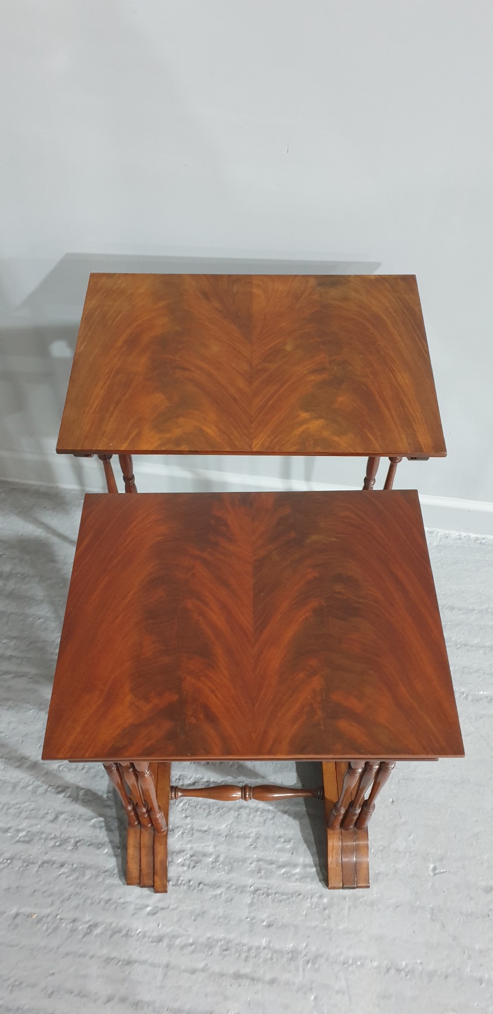 A set of four Edwardian mahogany nesting tables with rectangular tops, slender turned legs, and stretcher bases. View V