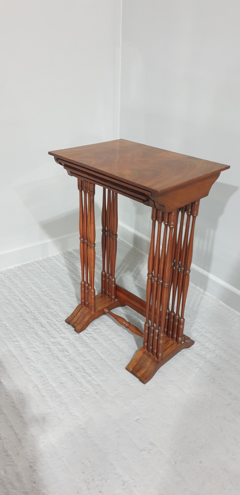 A set of four Edwardian mahogany nesting tables with rectangular tops, slender turned legs, and stretcher bases. View VII