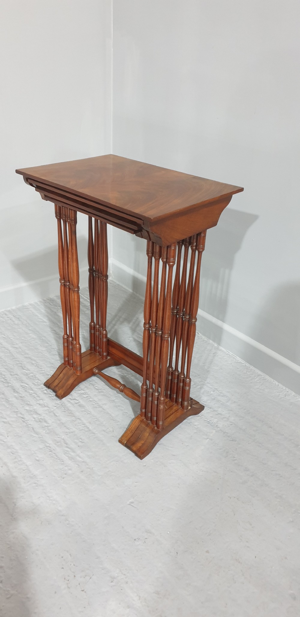 A set of four Edwardian mahogany nesting tables with rectangular tops, slender turned legs, and stretcher bases. View VIII