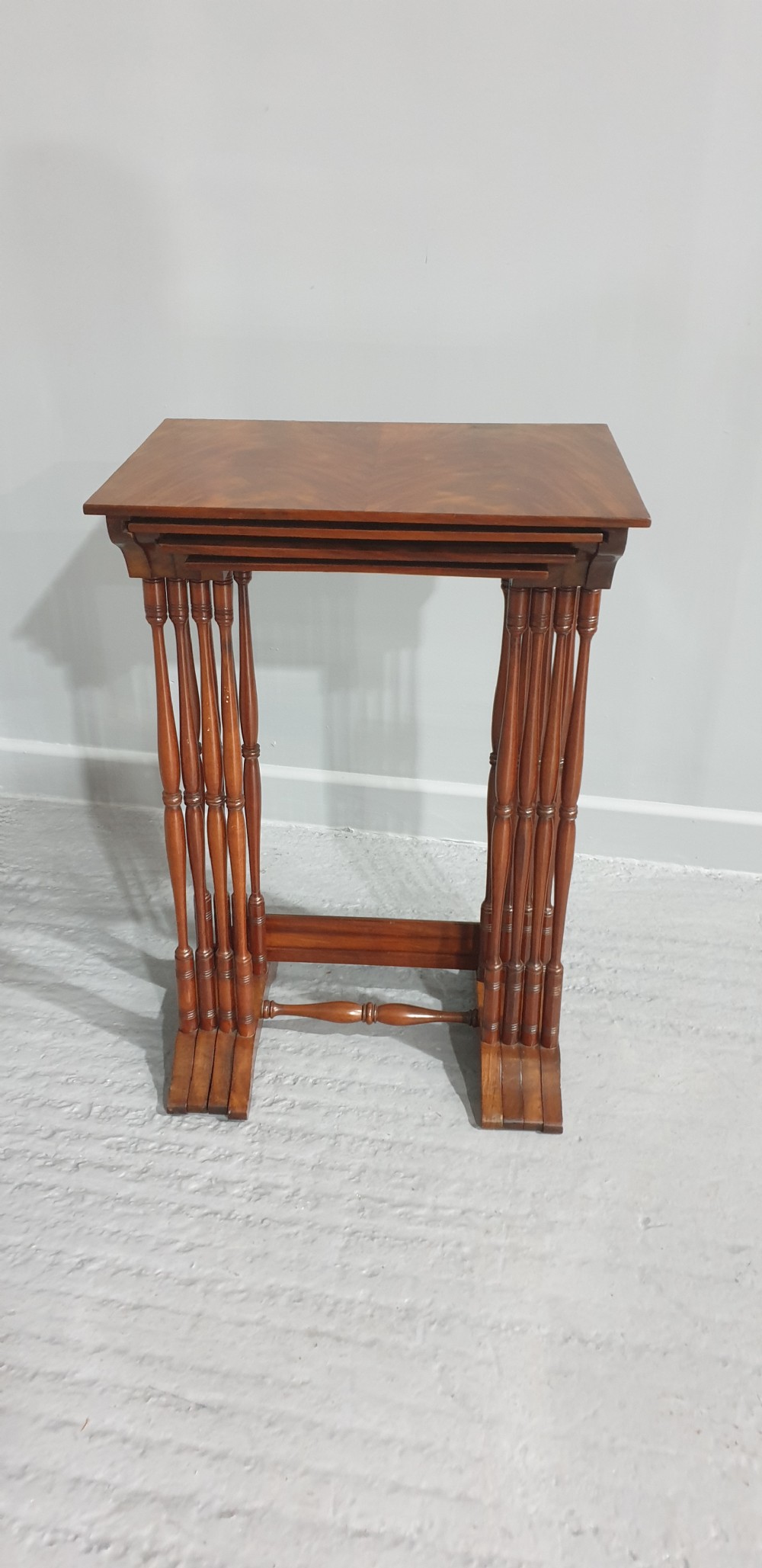 A set of four Edwardian mahogany nesting tables with rectangular tops, slender turned legs, and stretcher bases. View IX