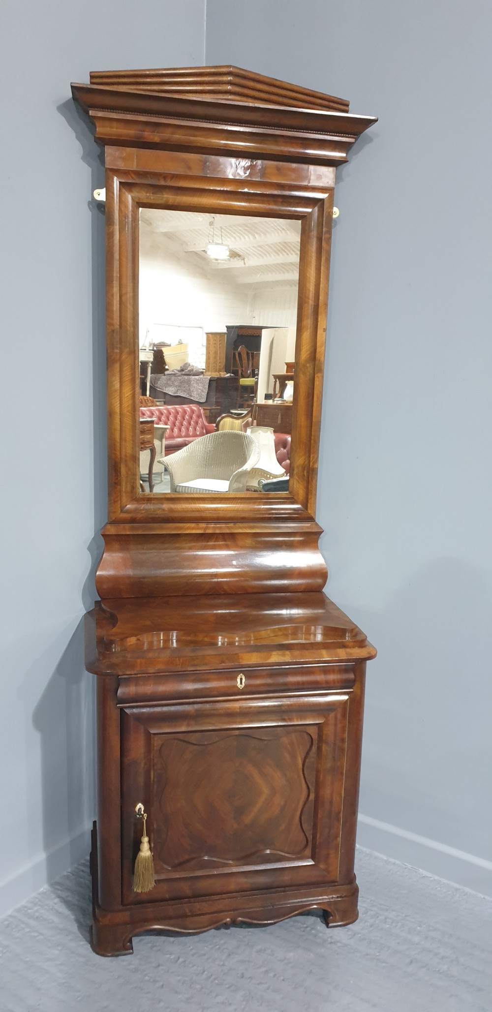An antique Biedermeier tall warm brown veneered console cabinet featuring a fitted rectangular mirror above a single drawer and panelled cupboard base. View II