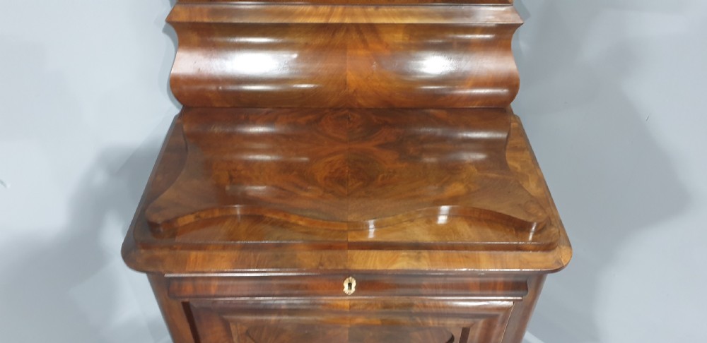An antique Biedermeier tall warm brown veneered console cabinet featuring a fitted rectangular mirror above a single drawer and panelled cupboard base. View VI