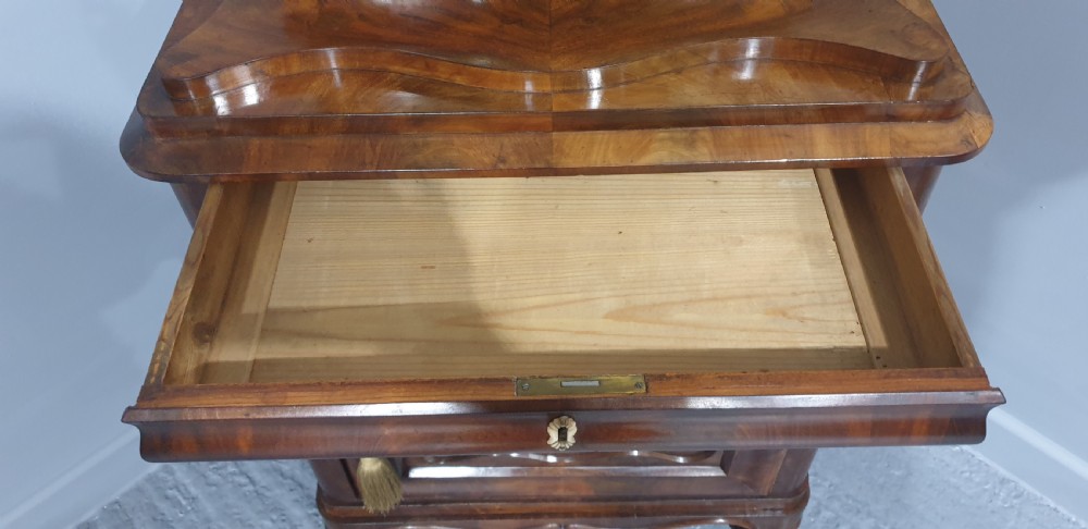 An antique Biedermeier tall warm brown veneered console cabinet featuring a fitted rectangular mirror above a single drawer and panelled cupboard base. View X