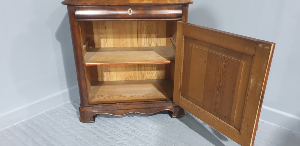 An antique Biedermeier tall warm brown veneered console cabinet featuring a fitted rectangular mirror above a single drawer and panelled cupboard base. View XI