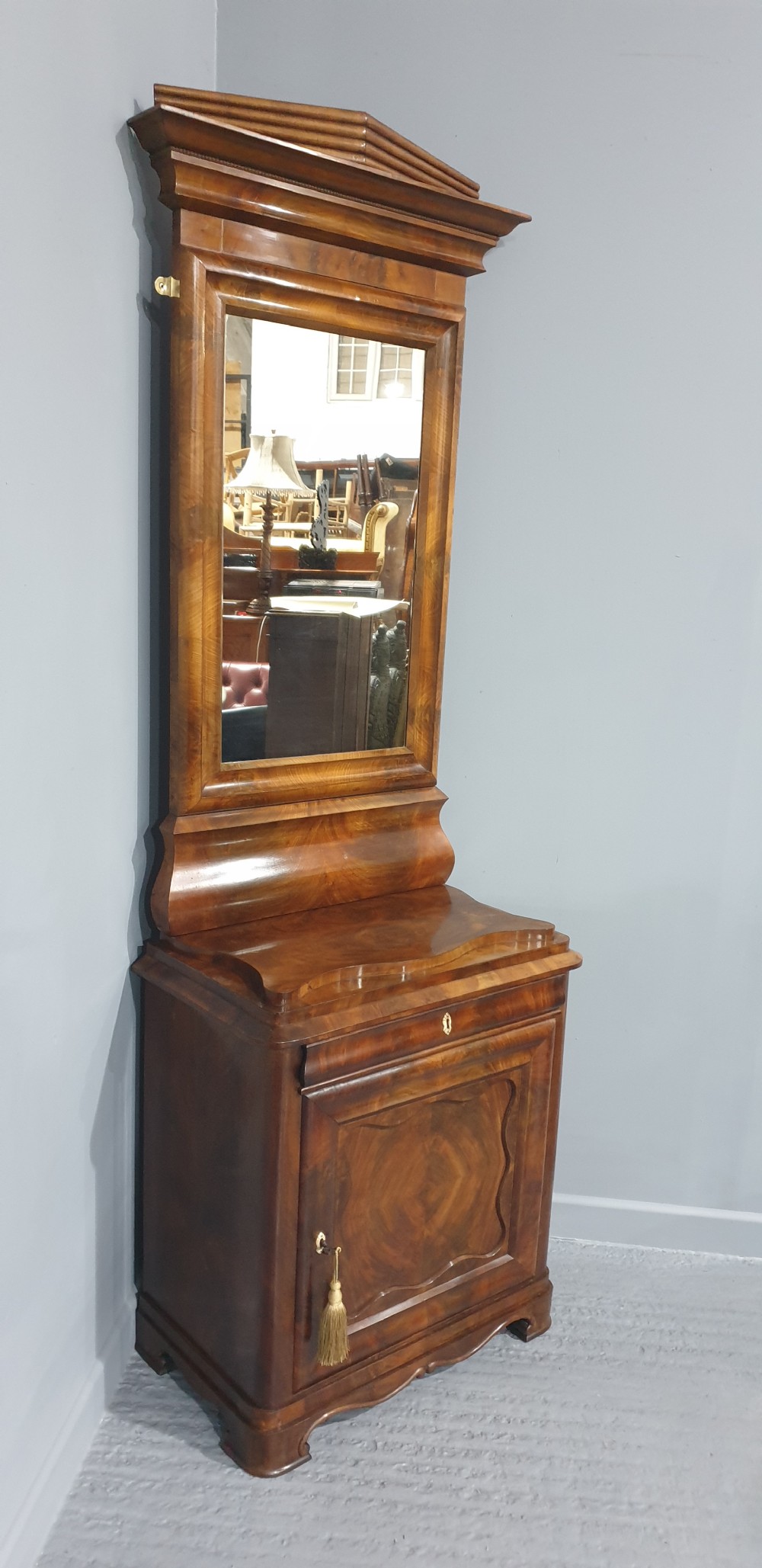 An antique Biedermeier tall warm brown veneered console cabinet featuring a fitted rectangular mirror above a single drawer and panelled cupboard base. View XIV