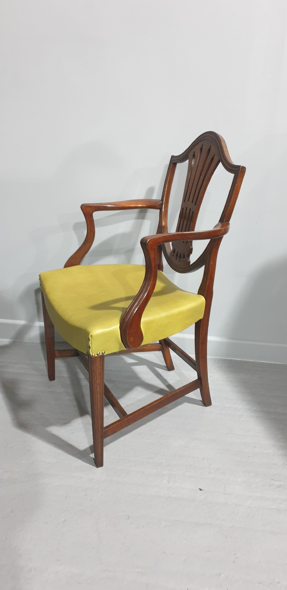 A set of six Georgian mahogany shield-back dining chairs, including two carvers and four side chairs, featuring yellow-green leather seats with brass studding. View XIII
